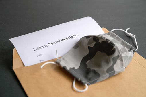 Notice to tenant for eviction inside brown envelope and face mask on top.