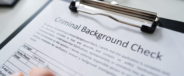 Close-up Of Human Hand Filling Criminal Background Check Application Form With Pen